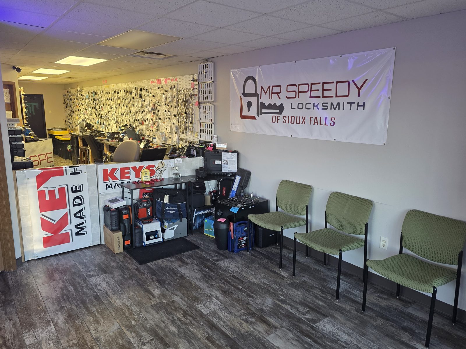 Inside Mr. Speedy Locksmith of Sioux Falls, with a wall of car keys and fobs behind the counter and the shop banner
